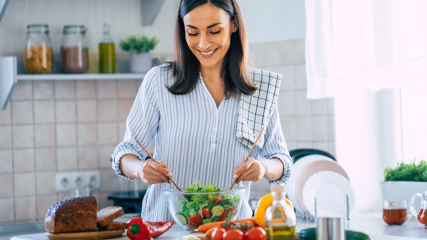 Një grua e re po përgatit një vakt të shëndetshëm.
