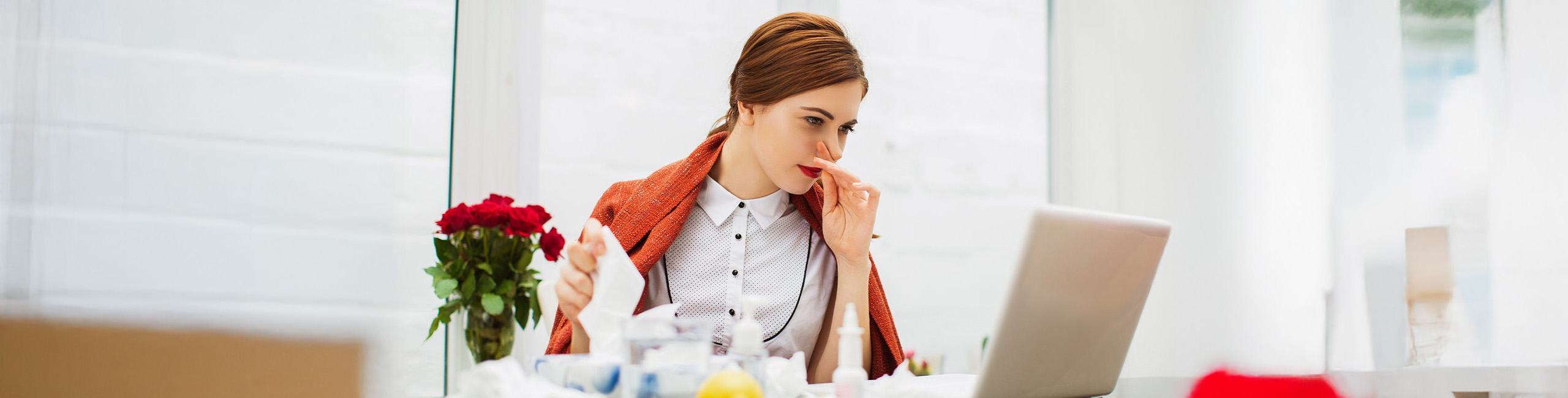 Grua e sëmurë me të ftohtë në zyrë.
